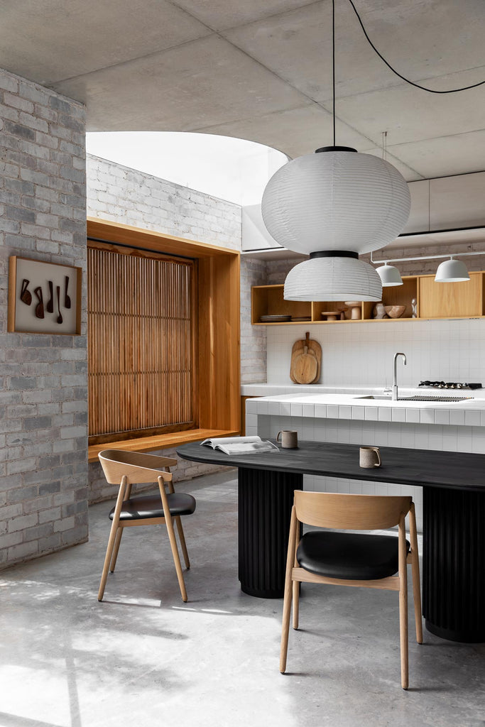 Underline Table – sculptural dining table in Black Oak with hollow cylindrical bases